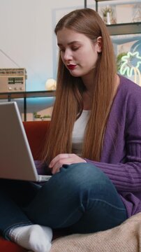 Displeased woman use laptop notebook typing browsing working, loses becoming surprised sudden lottery results bad news fortune loss fail computer virus. Portrait of lady at home in room on couch