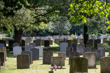 Naklejka premium Rows of old headstones and graves in the churchyard cemetery of St Nicholas Church, Ashchurch, Gloucestershire, England