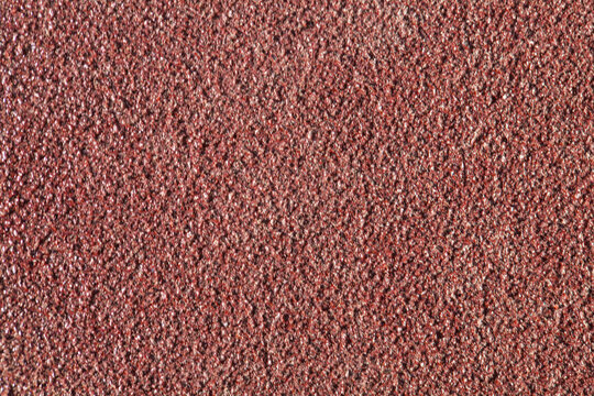 Red sandpaper stone background texture.