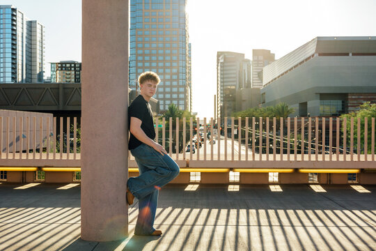 Young man posing on a city bridge