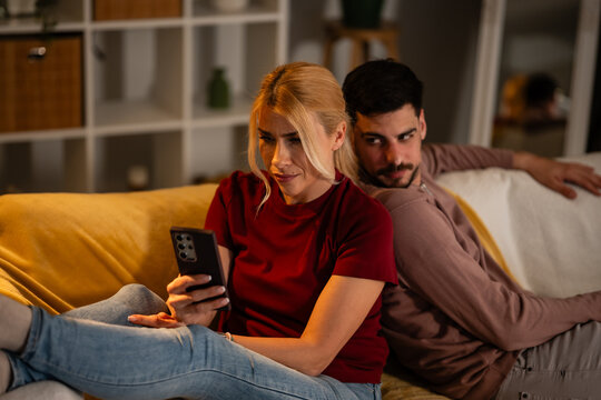 Jealous man spying partner's phone in unhappy relationship