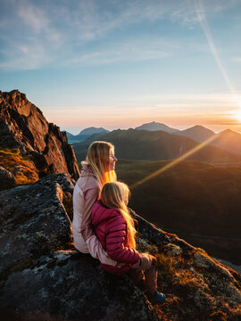 Family mother and child hiking in mountains together parent and child enjoy summer midnight sun view in Norway outdoor, active vacations healthy lifestyle camping trip bonding moments candid emotions