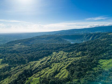 Aerial view of a hot tropical forest landscape and rural area with an extinct volcano and a lake called Laguna de Hule in the province of Alajuela in Costa Rica