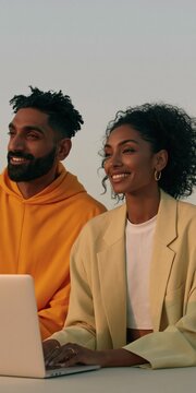 Smiling diverse young couple working on a laptop together for website banner and team collaboration background