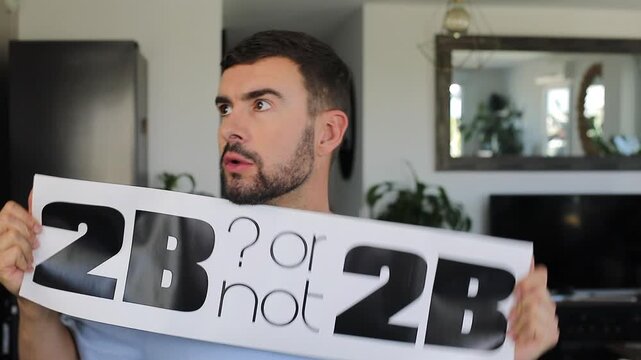 Man holding "TO BE or not TO BE" sign