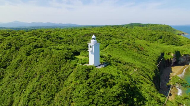 森の中から日本海を望む加佐の岬灯台 ドローン至近距離空撮 右旋回 / Close-up aerial drone orbiting right around Cape Kasa lighthouse revealing the Sea of Japan from the green forest