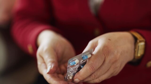 Close-up of an elderly woman handling prescription medication at home. Healthcare, treatment adherence, senior wellness and healthy aging.