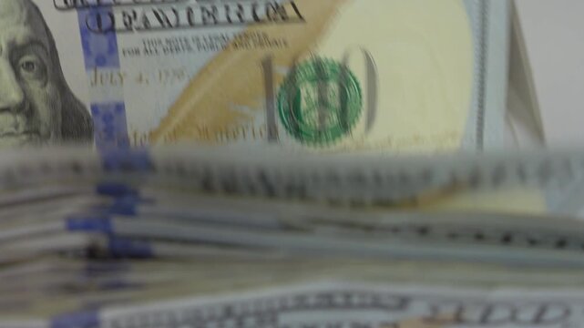 Money Counting Machine Processing American Hundred Dollar Bills, close up shot, soft focus, slow motion