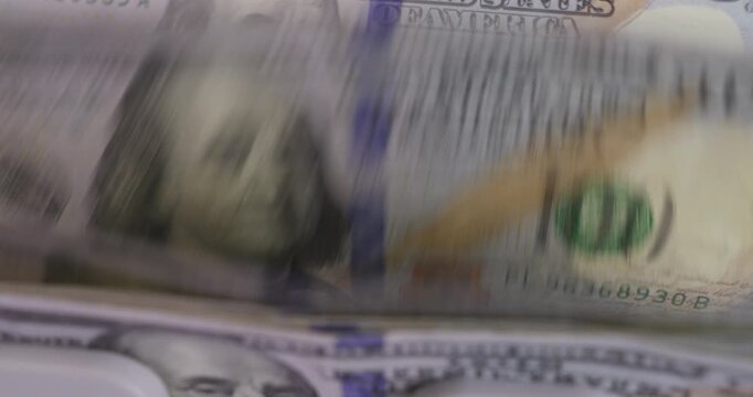 Money Counting Machine with Red Digital Display Processing a Stack of US 100 Dollar Bills	