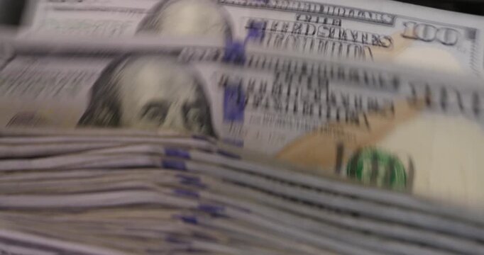 Money counting machine processing 100 Dollar bills, close up jib studio shot, slow motion