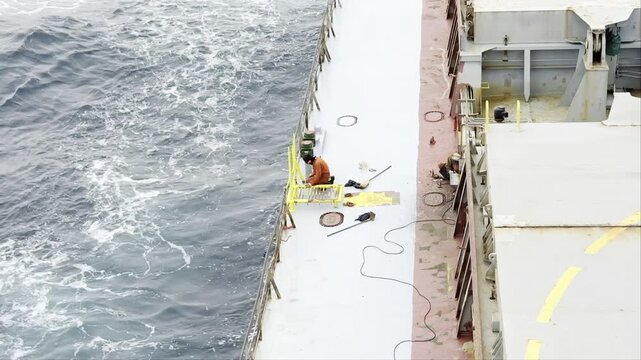 job of the ship crew during the sea passage. fitter weld new platform, ordinary seaman paint pilot entrance railings. seaman life and work. 