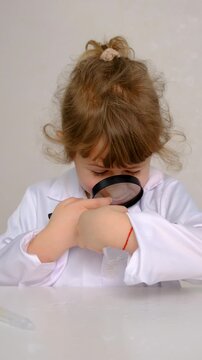 Laboratory examination of a child with test tubes, reagents and a microscope. Selective focus.