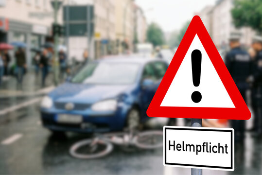 Ein Unfall zwischen einem Auto und einem Fahrrad und ein Verkehrsschild Helmpflicht