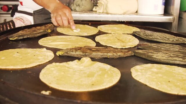 Mexican cook cooking traditional tortillas and tlacoyos