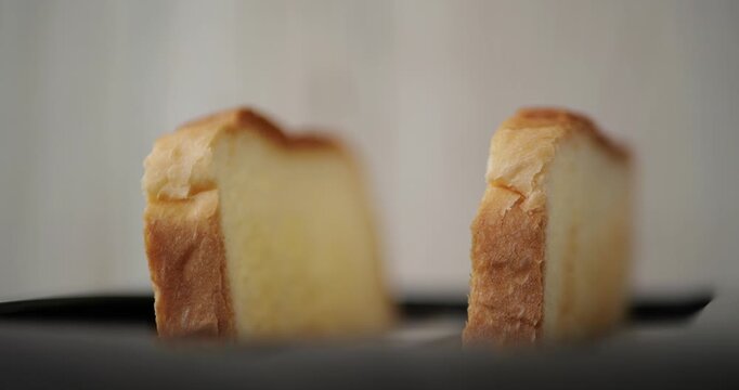 Delicious slices of fresh bread on black plate. Soft texture and golden crust create perfect breakfast option. Ideal for food photography and culinary projects.