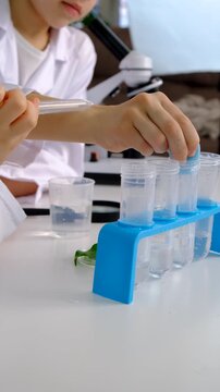 Laboratory examination of a child with test tubes, reagents and a microscope. Selective focus.