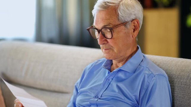 Older adult reviewing a utility bill and household expenses. Financial responsibility, budgeting and retirement finances.