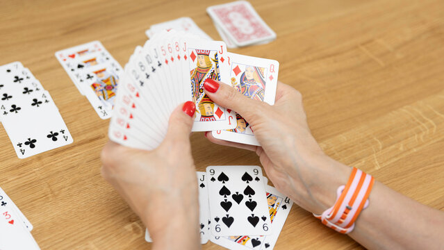 Woman's hands holding a fan of playing cards &mdash; card game, leisure, entertainment