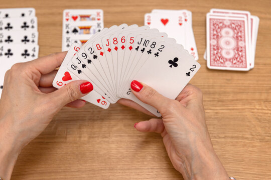 Woman's hands holding a fan of playing cards &mdash; card game, leisure, entertainment