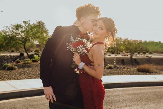Prom date kissing girlfriend's cheek 