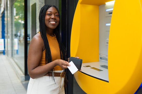 Black woman holding credit card at atm