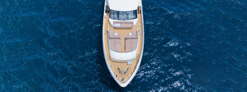 Aerial drone photo with copy space of luxury yacht with wooden deck cruising in high speed deep blue Aegean sea