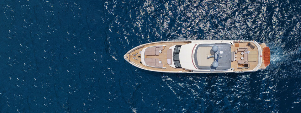 Aerial drone ultra wide panoramic photo with copy space of latest technology modern yacht with wooden deck anchored in deep blue Aegean sea