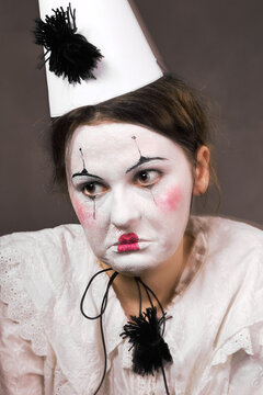 Sad woman in clown makeup looking away with melancholic or worried expression