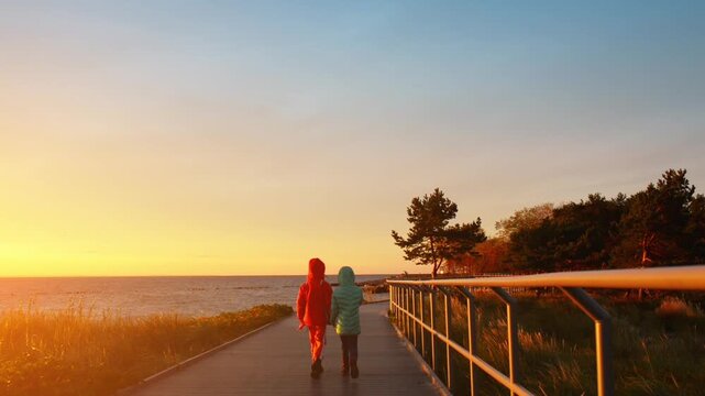 Two sisters walking along shore of Baltic Sea