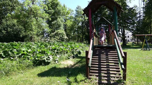 Two beautiful sisters run around the playground. Slow motion.