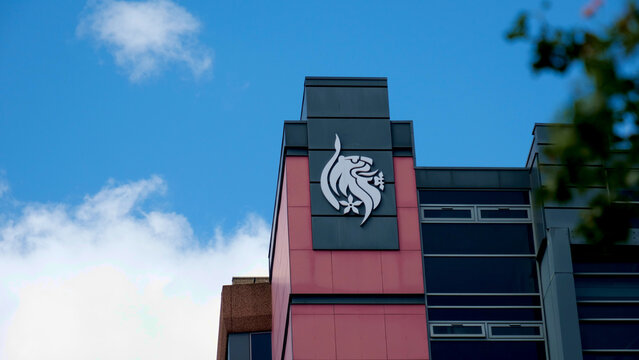 Leicester, England, UK - 13 June 2026: De Montfort University heraldic lion logo sign on modern campus building facade against blue sky, Leicester, United Kingdom