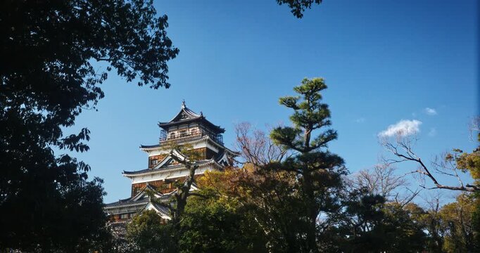 Hiroshima Castle Multi-Tier Pagoda Tower Framed by Trees  With Blue Sky