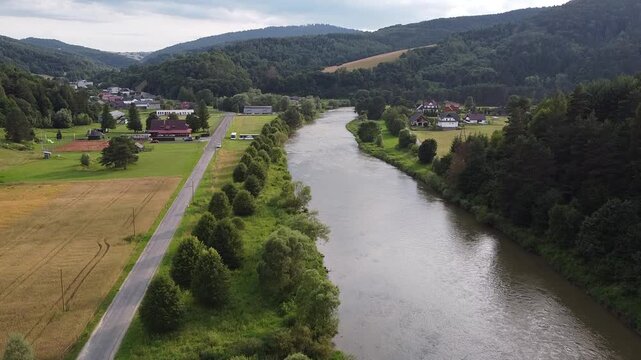 Aerial view of EuroVelo 11 bike path along Poprad river in summer, drone shot of scenic cycling route between Krynica-Zdroj, Muszyna and Rytro in Beskid Sadecki mountains, Poland.