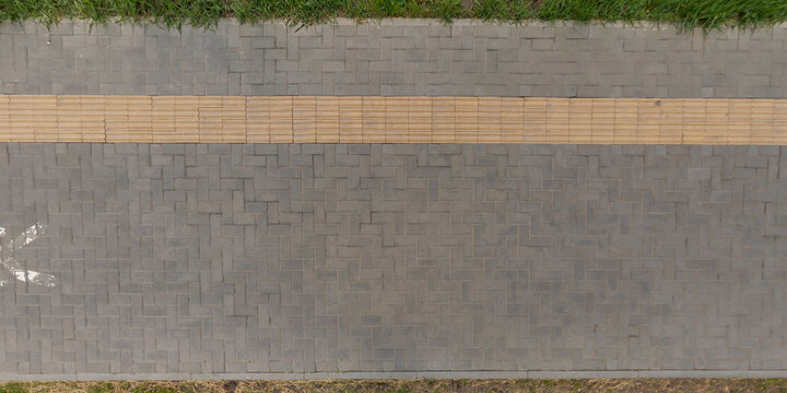 top view of surface of pedestrian path with paving slabs with the border of light and shadow