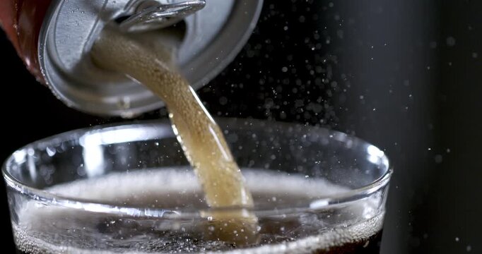 Pouring soda into a glass in slow motion with detailed movement