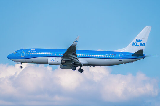 KLM Royal Dutch Airlines Boeing 737-800 passenger jet, registration PH-BGA, descending for landing against a cloudy sky.