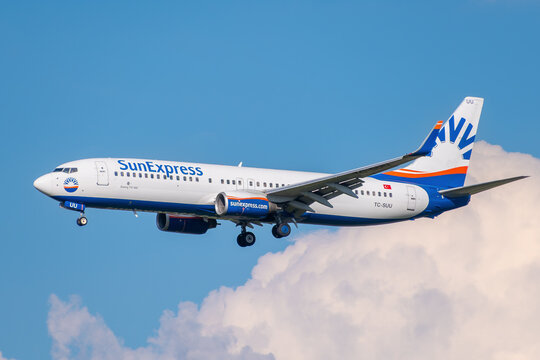 SunExpress Boeing 737-800 passenger jet, registration TC-SUU, descending for landing against a cloudy sky.