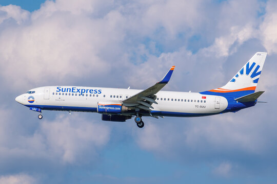 SunExpress Boeing 737-800 passenger jet, registration TC-SUU, descending for landing against a cloudy sky.