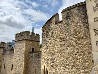 Medieval Castle Towers: High angle view of multiple white stone turrets featuring cream mortar and defensive archer slits against a cloudy blue sky © Curiosity Photos