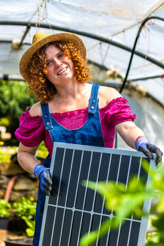 Woman holding a solar panel, promoting green energy and environmental sustainability