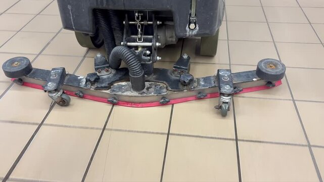 The operation of the rear scraper of an industrial floor scrubber. The efficiency of industrial cleaning equipment.