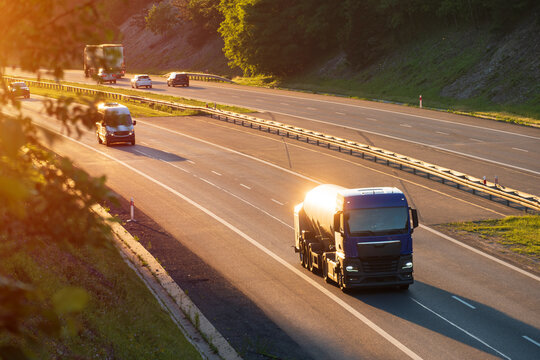 Blue Fuel Tanker Truck Driving on Highway During Golden Hour Sunset, The Concept of Energy Distribution