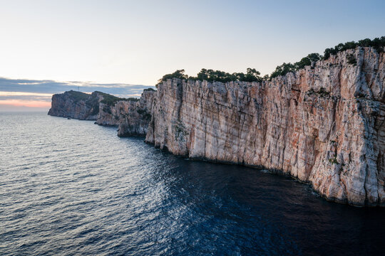 Majestic limestone cliffs of Telascica Nature Park at dusk rising from the Adriatic Sea, Croatia