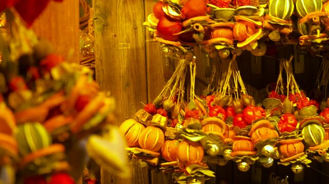 Traditional christmas market spiced decorations hanging. Natural handmade christmas decorations with dried orange slices, cinnamon sticks, berries, and jingle bells hanging at a festive market stall