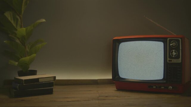 Retro TV background video loop, with copy space. Retro television concept with a old black and white TV displaying static noise and some videotapes
