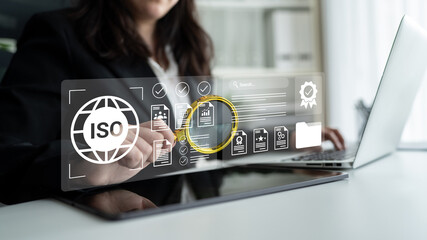 A professional businesswoman utilizes a laptop and virtual interface, focusing on ISO standards and...