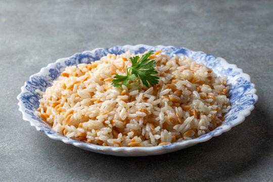 Traditional Turkish style rice pilaf with orzo garnished with a fresh parsley leaf served