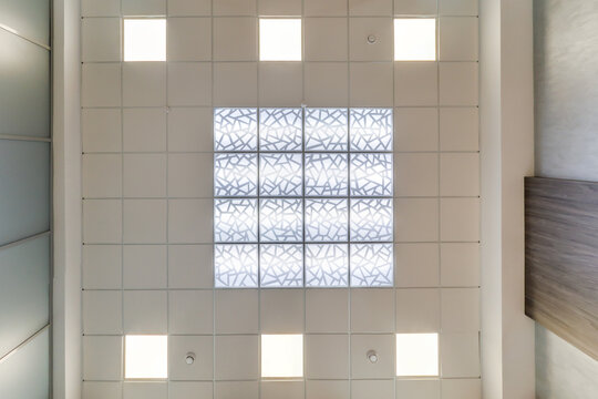 suspended ceiling with halogen spots lamps and drywall construction in empty room in apartment or house. Stretch ceiling white and complex shape.