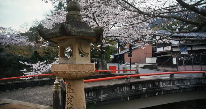 Ancient Stone Lantern on Bridge with Spring Cherry Blossoms In Hiroshima Japan - Steady Cam Movement