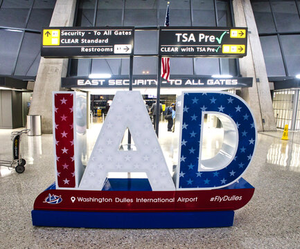 Patriotic IAD letter display at Washington Dulles International Airport, located near the East Security entrance with signage for TSA PreCheck, CLEAR, and restrooms visible in the background. 